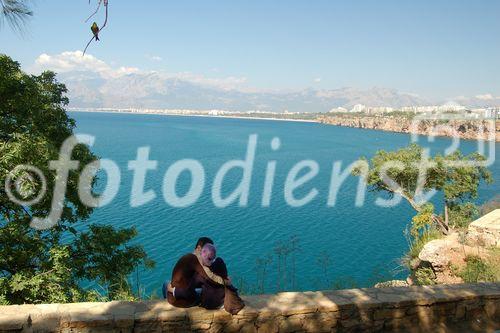 Lovers in the park at the old town of Antalya with a spectacular view to the mountains on the other side of the Bay. Liebespaar im Park in der Altstadt von Antalya mit fantastischem Ausblick über die Bucht, das Meer und mit Sicht in die Berge