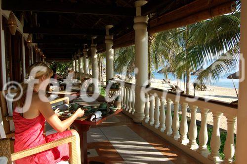 Frau geniesst herrliche AUssicht auf den Strand von Nha Trang von der Frühstücks-Veranda des Luxus-Hotels Ana Mandara Resort & Spa. Wonderfull view to the beach of Nha Trang from the breakfast-veranda of the luxury hotel Ana MAndara 