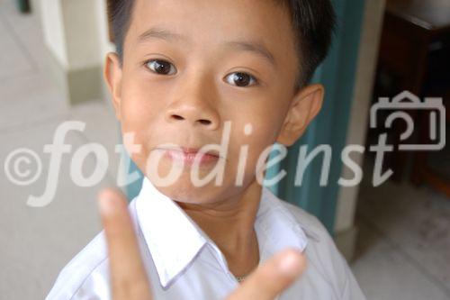 Vietnamese boy and schoolkid making the victory sign. Vietnamesischer Schuljunge zeigt Victory Kreuz