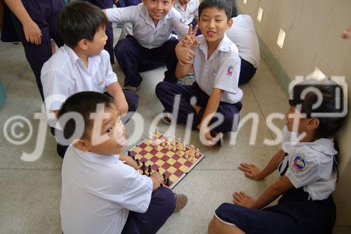 Vietnames schoolkids playing chest. Vietnamesische Schulkinder spielen Schach in der Pause