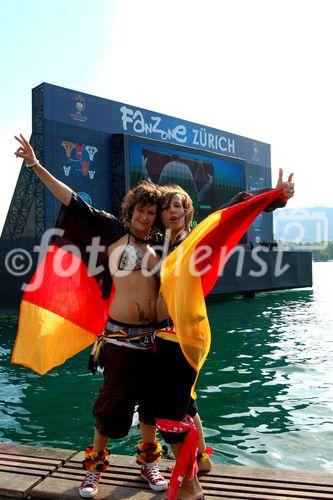 Zwei Deutsche Fussballfan-Frauen posieren freudig wie Engel vor dem TV-Monitor im Zürichsee. German female footballfans posing in front of the TV-Monitor at the lake Zürich.