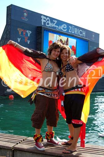 Zwei Deutsche Fussballfan-Frauen posieren freudig wie Engel vor dem TV-Monitor im Zürichsee. German female footballfans posing in front of the TV-Monitor at the lake Zürich.