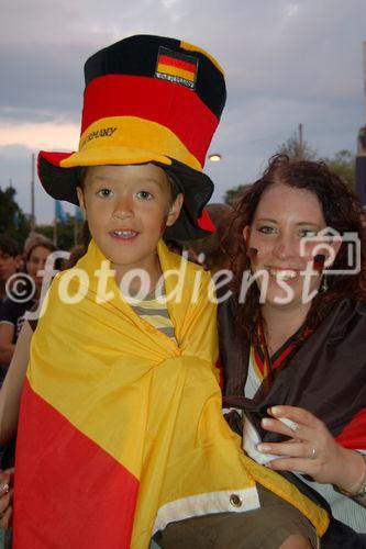 Junger stolzer Knabe mit seiner Mutter am Spiel Deutschland-Türkei. Young german footballfan-boy with his mother watching the football-match Germany-Turkey