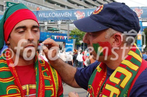 Portugiesische Fussballfans tragen die Kriegsbemalung vor dem Spiel gegen Deutschland auf und schminken sich mit den portugiesischen NAtionalfarben