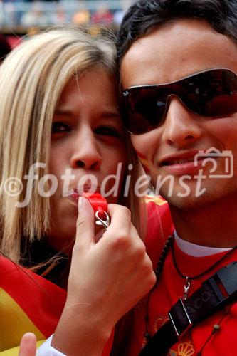 Spanisches Fussballfan-Paar. Sie gibt den Ton an, er trällert dazu und tanzt nach ihrer Pfeife. Spanish footballfan-couple. She gives the tone, he is shouting, crying and showing emotions