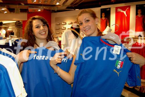 Zwei Frauen mustern Azzuri-Fan-Trikots im Jelmoli World of Sports. Women trying and buying Azzuri-football-T-Shirts