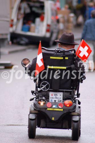 Fussball-Rollstuhlfahrer mit Schweizer Fahnen auf einer BAsler 