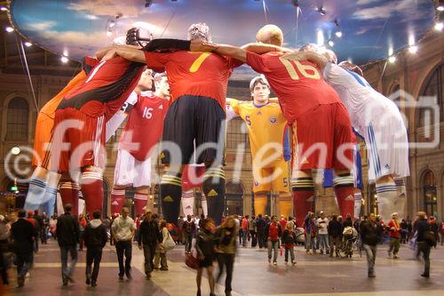 Im Zürcher Hauptbahnhof sind elf 17 Meter hohe Fussballer-Statuen von den EM-Mannschaften für die Euro 2008 aufgestellt, welche die Leute bestaunen.