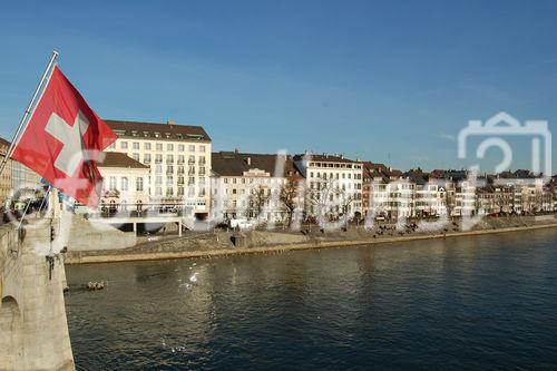 Rheinbrücke in Basel mit Euro 08 Flaggen und Häuserzeile am Flussufer. 
Switzerland, Basel, bridge over rhein-River, Euro 08 flags, people, houses, city, 
