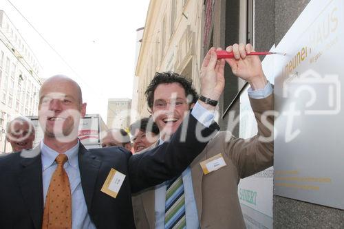 Michael Walk und Markus Reiter (beide GeschŠftsfŸhrer neunerHAUS) befestigen die Tafel. Das neunerHAUS bietet Menschen in akuter Wohnungslosigkeit Unterschlupf.