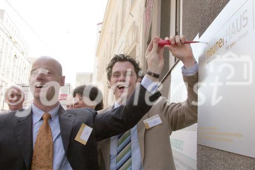 Michael Walk und Markus Reiter (beide GeschŠftsfŸhrer neunerHAUS) befestigen die Tafel. Das neunerHAUS bietet Menschen in akuter Wohnungslosigkeit Unterschlupf.