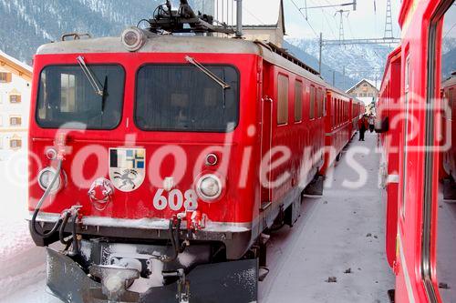 Kreuzende Züge des Glacier Express und Lokomotive der Rhätischen Bahn im Engadin. 
