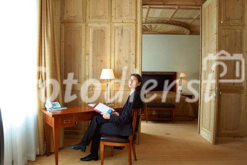 Eine mit wunderschönen Arven-Holz Ornamenten dekorierte Decke und gemütlich eingerichtete Suite im Grand Hotel Kronenhof in Pontresina.