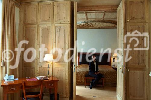 Eine mit wunderschönen Arven-Holz Ornamenten dekorierte Decke und gemütlich eingerichtete Suite im Grand Hotel Kronenhof in Pontresina.