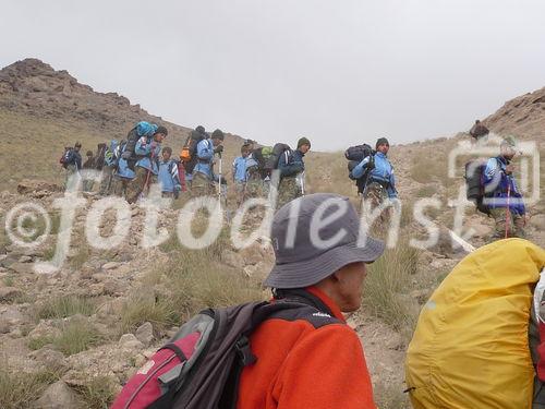 (C)Fotodienst/ Dr. Wilfried Seywald; Vom Basislager Gusfandsara auf 3.150 m geht es zu Fuß bergauf Richtung Damavand. Bis zur Schutzhütte Bargah-e Sevom auf 4.150 m passiert man Almwiesen mit Schaf- und Ziegenherden, Schotterfelder, bizarre Basaltgesteine, trockene Bachläufe, Lavafelder und zum Schluss vulkanisch geprägte Felslandschaften. Im Bild: Abstieg von iranischen Militärangehörigen.