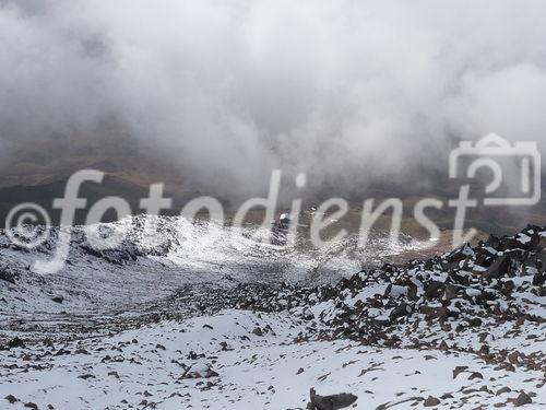 (C)Fotodienst/ Dr. Wilfried Seywald; Die im vergangenen Jahr errichtete Schutzhütte Bargah-e Sevom auf 4.150 m bietet bis zu einhundert Bergsteigern Unterkunft. Im Bild: Blick vom Lager hinauf auf den wolkenverhangenen Damavand.