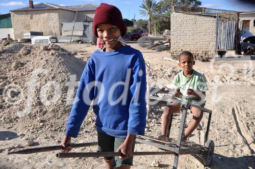 Namibische Kinder beim Spiel und Nachahmung eines Pferde- oder Eselgespanns. Namibi children playing horses and donkey. 