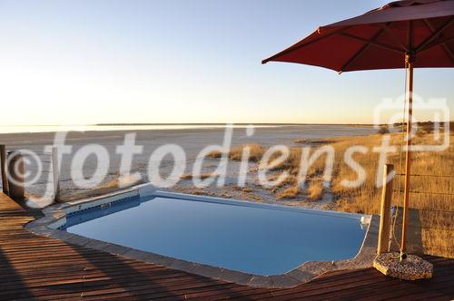 Entspannen Sie sich und geniessen Sie die herrliche Aussicht auf die Etosha-Salzpfanne vom Pool des Onkoshi Camps aus. Dieses Luxus-Lodge liegt nahe Namutomi und gehört zu den Namibia Wildlife Resorts. www.nwr.com.na.