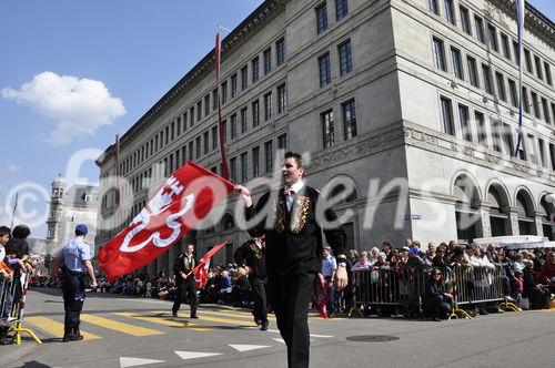 Fahnenschwinger vor dem Zürcher Nationalbank-Gebäude am Sechseläuten-Umzug. 