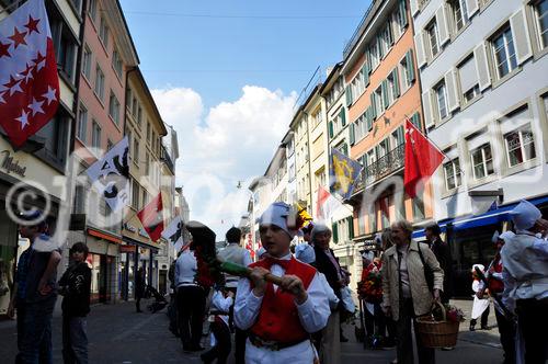 Die reich mit Fahnen geschmückte Augustinergasse am Sechseläuten-Umzug, dem Fest der Zürcher Zünfte und Zunftleute. The rich with flags decorated Augustinergasse in Zürichs old town at the traditional Sechseläuten-Parade