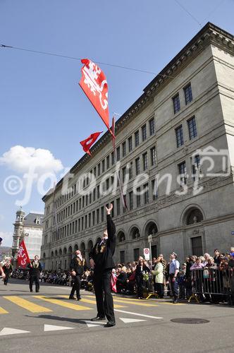 Fahnenschwinger vor dem Zürcher Nationalbank-Gebäude an der Sechseläuten-Parade, dem Fest der Zunftleute