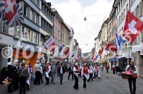 Die reich mit Fahnen geschmückte Augustinergasse am Sechseläuten-Umzug, dem Fest der Zürcher Zünfte und Zunftleute. The rich with flags decorated Augustinergasse in Zürichs old town at the traditional Sechseläuten-Parade