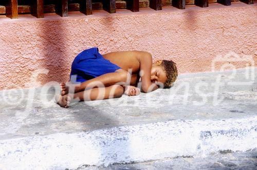 Brasilianischer Straßenjunge schläft seinen Drogenrausch auf dem Gehsteig in Fortaleza bis am Mittag aus. 