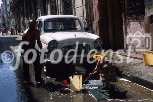 Ein Kubaner wäscht seinen Oldtimerl in Havanna. Seine Tochter hilft ihm dabei. Ohne fließend Wasser gar nicht so einfach. A cuban men is washing his oldtimer in HAvanna vjeja. But without current water not so easy.