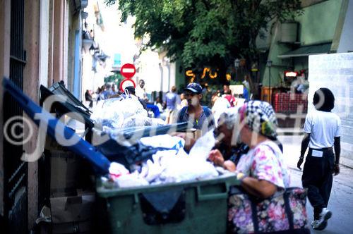 Hungernde Kubaner durchwühlen einen Abfallcontainer auf der Suche nach Nahrung. Hungry cuban people are searching for food in a garbage-container in Havanna