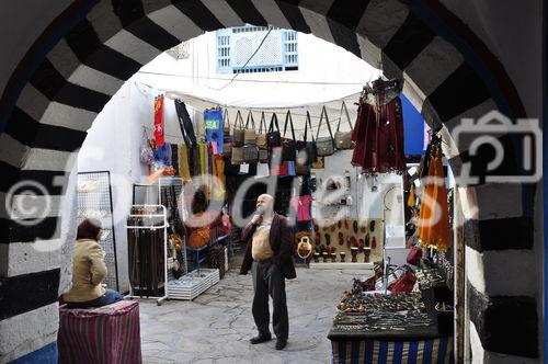 Unter den Torbögen und in den engen Gassen der Medina von Hamamet säumt sich ein Souk nach dem anderen. Die Souvenierverkäufer und Kunsthandwerker warten auf die Rückkehr der Touristen