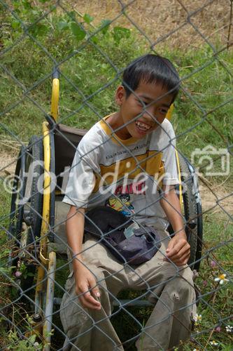 Behinderter Knabe in Vietnam beim Kriegsdenkmal des grausamen Massaker der US-Soldaten in Son My, wo 503 Personen, darunter viele Kleine Kinder starben.
Handicaped boy in a wheelchair near the war memorial Son My