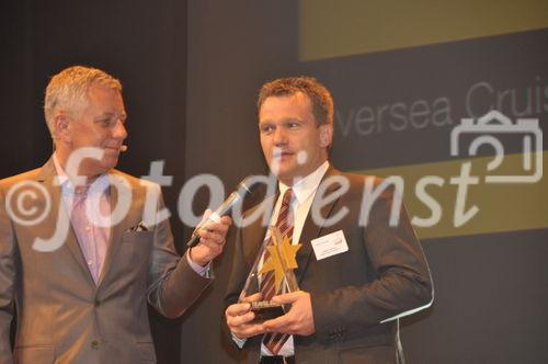 Travel Star Gewinner Carsten Sühring von Hapag Lloyd nimmt den begehrten Preis von TV-Moderator Röbi Koller entgegen.