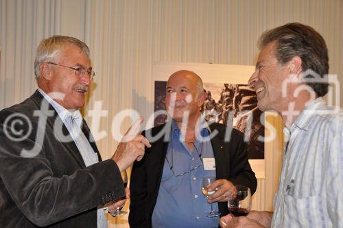 Albert Stahel, Roy Oppenheim und eine dritte Person debattieren an der Reporter ohne Grenzen Podiumsdiskussion über die Medienfreiheit in Krisenregionen und die Kriegsberichterstattung vor einem Bild des Fotografen Zalmaï Ahad 