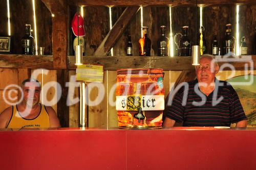 Die beiden langjährigen Bierbrauer der Brauerei in der historischen Scheune hinter dem Tresen und Ausschank mit dem innovativen Bierfass, dass sich selbst kühlt