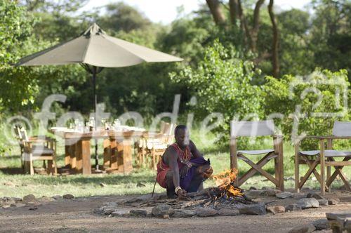 Ein Masaai entfacht ein Lagerfeuer im Mara Porini Camp für die Safari-Gäste im Masaai-Land