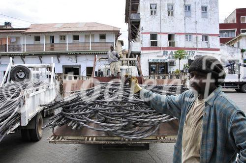 Iron-worker in the harbour of Mombasa are carring piece by piece of the heavy iron down to the ship in Mombasas harbour. Stahl wird von Arbeitern auf die Boote in Mombasas HAfen getragen