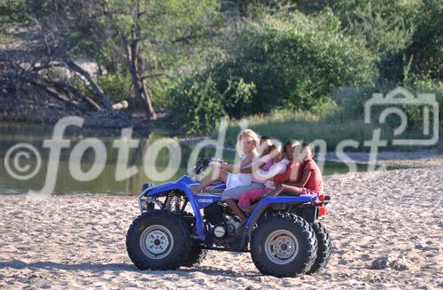 Frühreif und sprachbegabt die Tochter von Neltjie Bower fährt mit ihren Bushmen-Freunden auf dem Quad um's Wasserloch herum. Die Grassland Safari Lodge ist auch für Behinderte geeignet und bietet Bushmen-Fans  einen Einblick in das Leben der San-Kultur und Tradition. The daughter of Neltjie speaks the bushmen-language of the NAro San and drives her boy's around on the quad