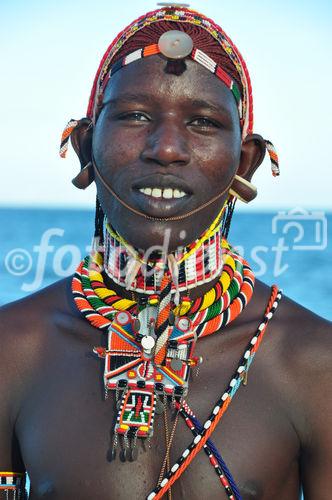 Masai Men with traditional neckrings. Junger Masai-Mann mit GTlasperlenschmuck um den Nacken