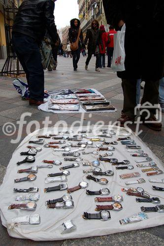 Illegale Uhren-Immitationen werden auf der Calle Arenal in MAdrid den PAssanten angeboten. Fake watches are sold illegaly on Calle Arenal in Madrids shopping mall