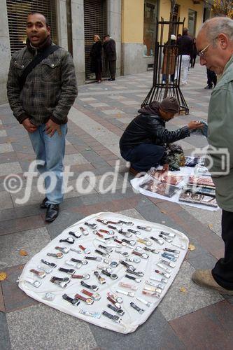 Illegale Machenschaften von Immigranten: Uhren-Immitationen werden auf der Calle Arenal in MAdrid den PAssanten angeboten. Fake watches are sold illegaly on Calle Arenal in Madrids shopping mall mainly through immigrants