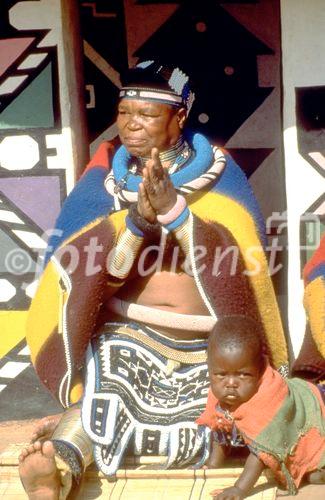 Grossartige Artisten und Kunsthandwerker: Ndebele-Frau mit Kind in traditionell bunter Bekleidung. Great artist, painters and handicraft from the Ndebeles, here a women with her child in traditional colourfull cloth