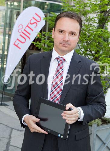 (C) fotodienst / Anna Rauchenberger  - Wien, 28.04.2011 – Fujitsu stellt mit 'Managed Smartphone' weltweit einen neuen Service zur Verfügung. Dank eines Pakets von gehosteten Mobile Professional-Lösungen können Unternehmen die Verwaltung ihrer Smartphones gezielt an Fujitsu auslagern und ihre betrieblichen Prozesse optimieren. FOTO: Johannes Baumgartner, Managing Director Fujitsu Österreich mit dem Multi-Touch-Gerät Fujitsu STLISTIC Q550