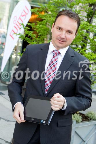 (C) fotodienst / Anna Rauchenberger  - Wien, 28.04.2011 – Fujitsu stellt mit 'Managed Smartphone' weltweit einen neuen Service zur Verfügung. Dank eines Pakets von gehosteten Mobile Professional-Lösungen können Unternehmen die Verwaltung ihrer Smartphones gezielt an Fujitsu auslagern und ihre betrieblichen Prozesse optimieren. FOTO: Johannes Baumgartner, Managing Director Fujitsu Österreich mit dem Multi-Touch-Gerät Fujitsu STLISTIC Q550