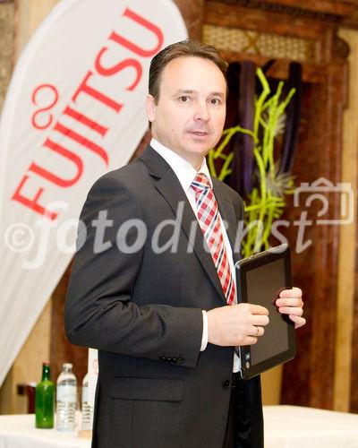 (C) fotodienst / Anna Rauchenberger  - Wien, 28.04.2011 – Fujitsu stellt mit 'Managed Smartphone' weltweit einen neuen Service zur Verfügung. Dank eines Pakets von gehosteten Mobile Professional-Lösungen können Unternehmen die Verwaltung ihrer Smartphones gezielt an Fujitsu auslagern und ihre betrieblichen Prozesse optimieren. FOTO: Johannes Baumgartner, Managing Director Fujitsu Österreich mit dem Multi-Touch-Gerät Fujitsu STLISTIC Q550