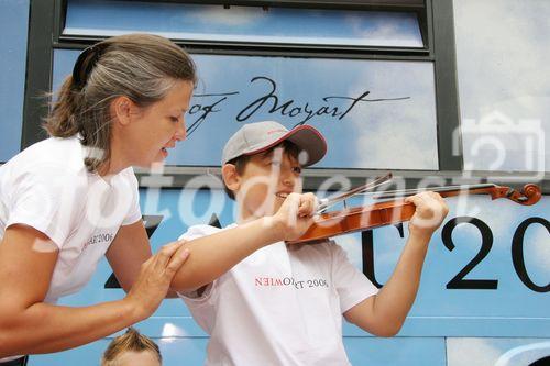 (C) fotodienst/Anna Rauchenberger - Wien 01.08.2006 - Ein bunt gestalteter Doppeldecker-Bus tourt durch Wien. Er bringt Musikinstrumente zum Anfassen und Ausprobieren in Schulen, Kindertagesstätten und andere Jugendeinrichtungen. Das klingende Mozart-Mobil soll Kinder und Jugendliche zum Musizieren animieren. FOTO: begeisteter zukünftiger Musiker und Musikpädagogin.