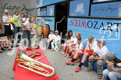 (C) fotodienst/Anna Rauchenberger - Wien 01.08.2006 - Ein bunt gestalteter Doppeldecker-Bus tourt durch Wien. Er bringt Musikinstrumente zum Anfassen und Ausprobieren in Schulen, Kindertagesstätten und andere Jugendeinrichtungen. Das klingende Mozart-Mobil soll Kinder und Jugendliche zum Musizieren animieren. FOTO: begeistete zukünftige Musiker und Musikpädagogin vor dem Mozart-Mobil.