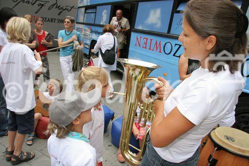 (C) fotodienst/Anna Rauchenberger - Wien 01.08.2006 - Ein bunt gestalteter Doppeldecker-Bus tourt durch Wien. Er bringt Musikinstrumente zum Anfassen und Ausprobieren in Schulen, Kindertagesstätten und andere Jugendeinrichtungen. Das klingende Mozart-Mobil soll Kinder und Jugendliche zum Musizieren animieren. FOTO: begeistete zukünftige Musikerin und Musikpädagogin vor dem Mozart-Mobil.