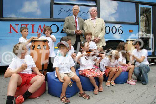 (C) fotodienst/Anna Rauchenberger - Wien 01.08.2006 - Ein bunt gestalteter Doppeldecker-Bus tourt durch Wien. Er bringt Musikinstrumente zum Anfassen und Ausprobieren in Schulen, Kindertagesstätten und andere Jugendeinrichtungen. Das klingende Mozart-Mobil soll Kinder und Jugendliche zum Musizieren animieren. FOTO: Peter Marboe (Intendant WIENER MOZART JAHR 2006, links), Gerd Albrecht (Initiator des Klingenden Museums in Hamburg und Berlin) und begeistete zukünftige Musiker vor dem Klingenden Mozart-Mobil.