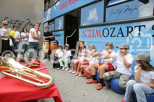 (C) fotodienst/Anna Rauchenberger - Wien 01.08.2006 - Ein bunt gestalteter Doppeldecker-Bus tourt durch Wien. Er bringt Musikinstrumente zum Anfassen und Ausprobieren in Schulen, Kindertagesstätten und andere Jugendeinrichtungen. Das klingende Mozart-Mobil soll Kinder und Jugendliche zum Musizieren animieren. FOTO: begeistete zukünftige Musiker und Musikpädagogin vor dem Mozart-Mobil.