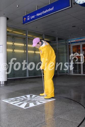 Linz - Hauptbahnhof Linz: der Ein- und Ausgang 'Kärntner Lichtauge' in Richtung Zentrum Stadt Linz ist hoch frequentiert. Über 15.000 Paar Füße sehen die Steine auf den Plätzen jeden Tag, das Pflaster ist verkrustet vom Schmutz. Damit bildet es den perfekten Untergrund für eine ganz neue Art von Kunst aus Großbritannien: 'Reverse Graffiti', auch 'saubere Kunst' genannt. Bei dieser Art des legalen Graffiti werden mit Hochdruckreinigern Kunstwerke auf den Boden 'gemalt'. Am Ende der Kunstaktion wird der gesamte Platz von einem Spezialteam gereinigt und erstrahlt somit in frühlingshaftem Glanz. 